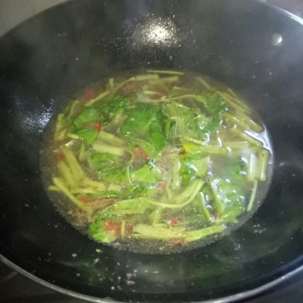 Masukkan kangkung, aduk sampai layu lalu tambahkan air. Masak sampai mendidih