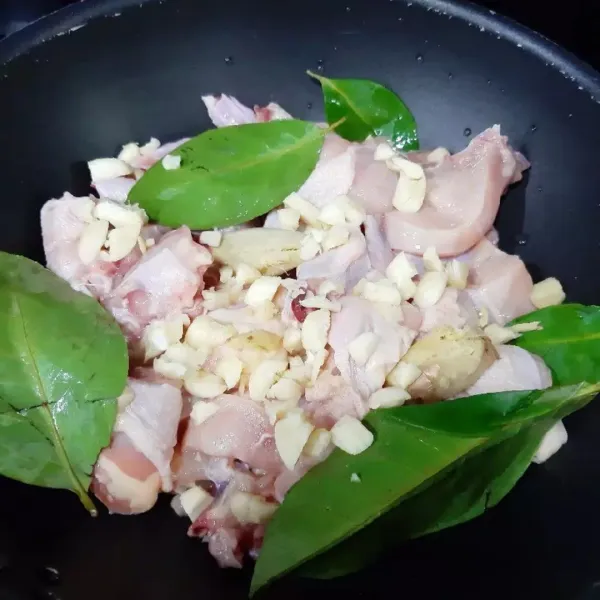 Bersihkan ayam lalu potong-potong. Taruh di kuali bersama lengkuas, jahe, daun salam dan 6 siung bawang putih yang dicacah