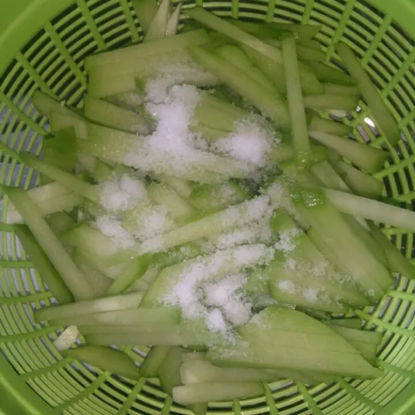 Labu siam potong korek api, lalu beri garam. Remas-remas sampai keluar air. Cuci bersih, tiriskan.