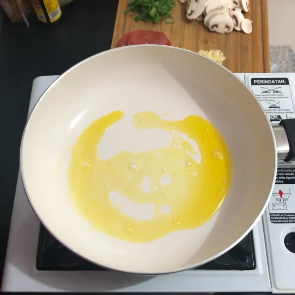 Lelehkan margarin, lalu tumis bawang putih dan jamur hingga harum.