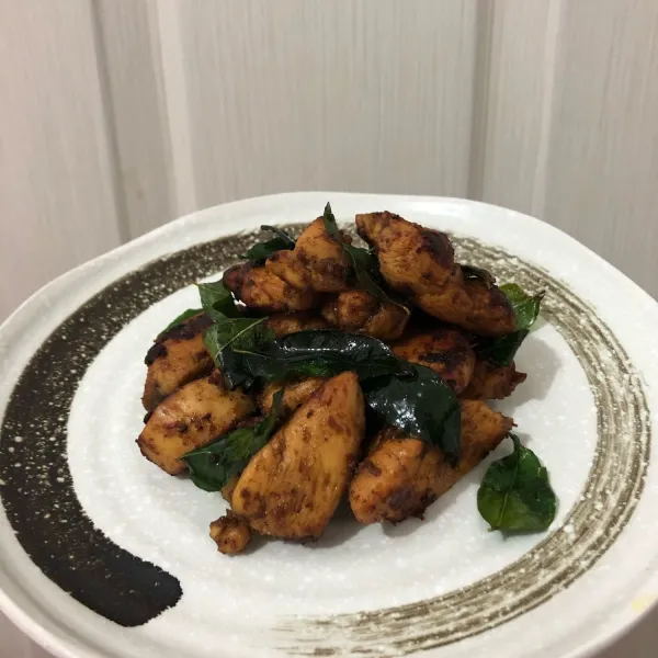 Sajikan ayam bersama dengan daun kari nya.