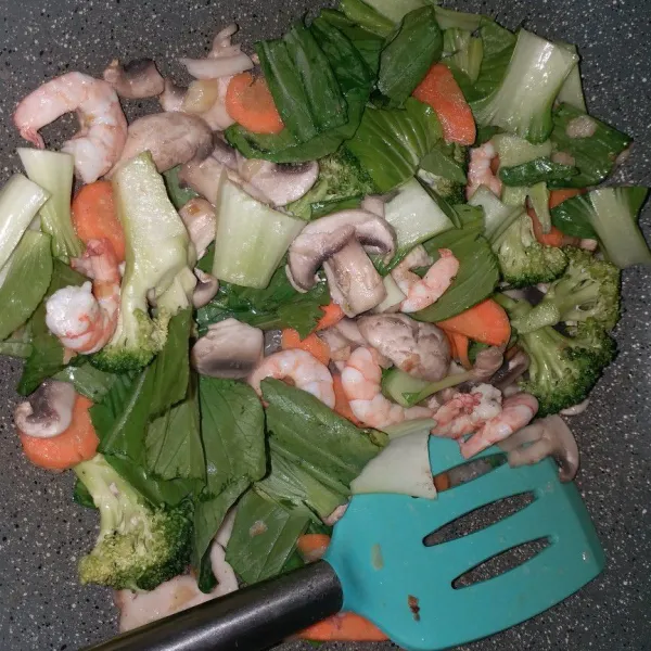 Masukkan sayuran dari teksturnya yang krras terlebih dahulu ke yang mudah matang, aduk-aduk