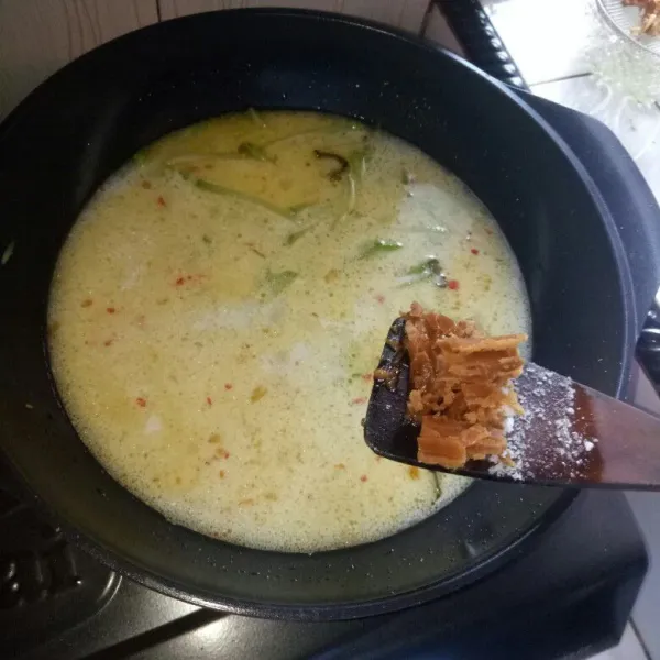 Masukkan gula merah, aduk rata. Aduk terus sampai santan mendidih.