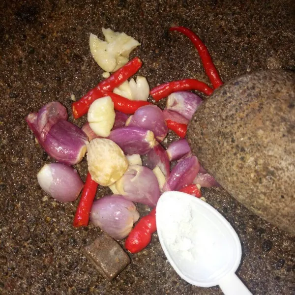 Siapkan cobekan, haluskan bawang merah, bawang putih, cabe merah, kemiri, terasi dan garam. Ulek sampai halus