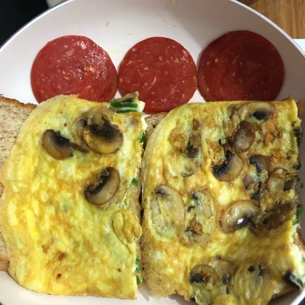Letakkan roti diatas telur, kemudian balikkan telur, kemudian masukkan salami di bagian wajan yang kosong, masak sebentar lalu letakkan diatas telur.