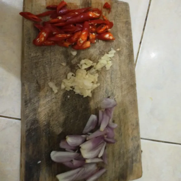 Iris tipis-tipis bawang merah, bawang putih, dan cabe merah