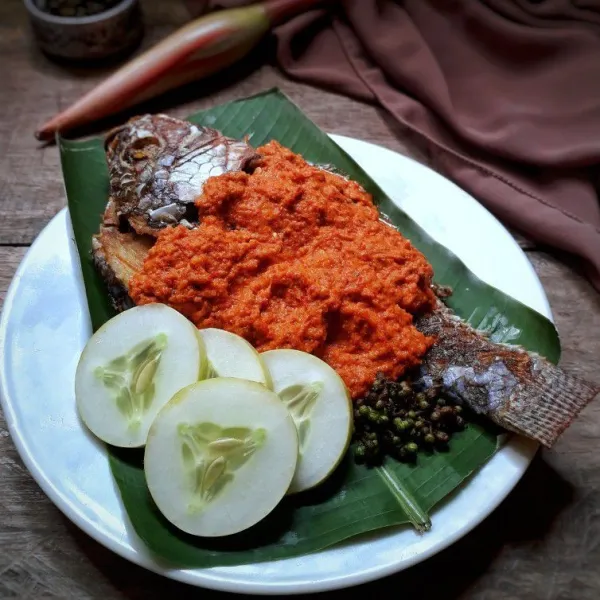 Tata ikan goreng di atas piring lalu siram dengan bahan sambal diatasnya