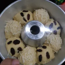 Letakkan adonan di loyang secara selang seling. Taburi dgn raisin dan keju di atasnya. Kemudian tutp dgn plastik wrap lg selama 30-45 menit tunggu smp mengembang