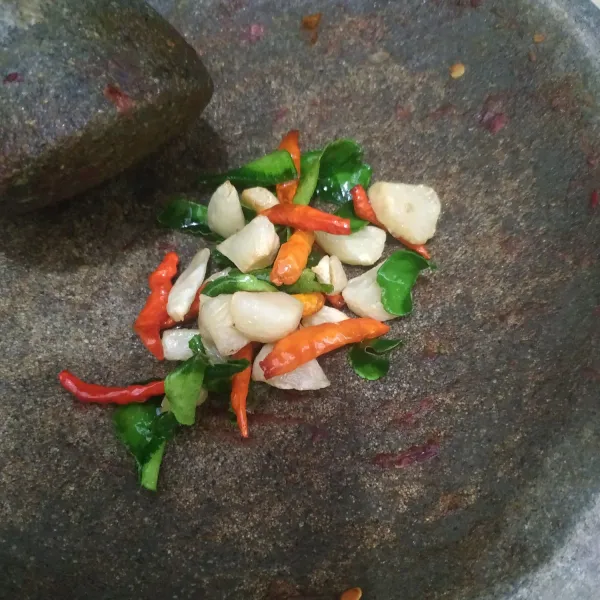 Haluskan bawang putih, cabe rawit, daun jeruk yang sudah digoreng, dan kencur