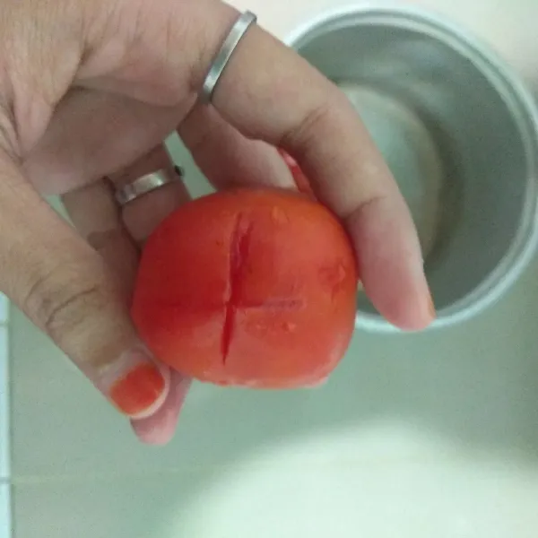 Buat saus tomat homemade, iris silang pada bagian bawah tomat