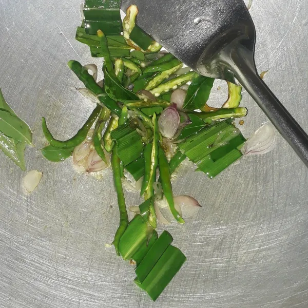 Panaskan minyak goreng secukupnya. Lalu tumis irisan bawang merah, daun pandan, daun temurui dan cabe keriting hijau. Tumis sampai layu