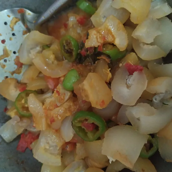 Masukkan kikil, beri garam, gula dan kaldu bubuk, aduk rata koreksi rasanya, masak sampai air agak berkurang