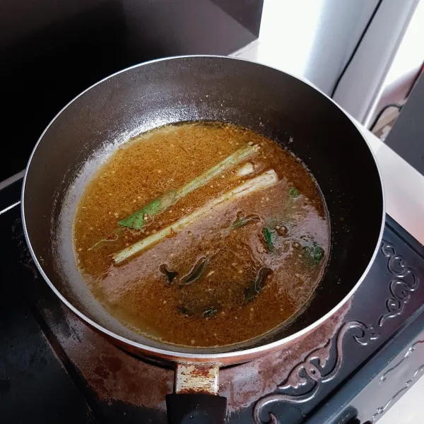 Masukkan daun salam, sereh, asam jawa, garam dan air kelapa ke dalam wajan. Lalu aduk-aduk sampai mendidih.