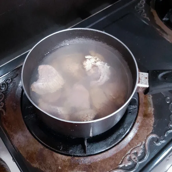 Setelah direndam di daun teh, cuci kembali daging dengan air mengalir lalu rebus daging bersama 500ml air selama 30 menit