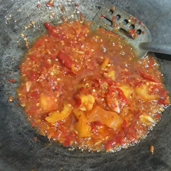 Goreng cabe merah dan tomat yang sudah di giling beri garam dan kaldu bubuk. Masak sampai bau langu hilang, matikan api baru masukkan jengkol dan ikan salar.