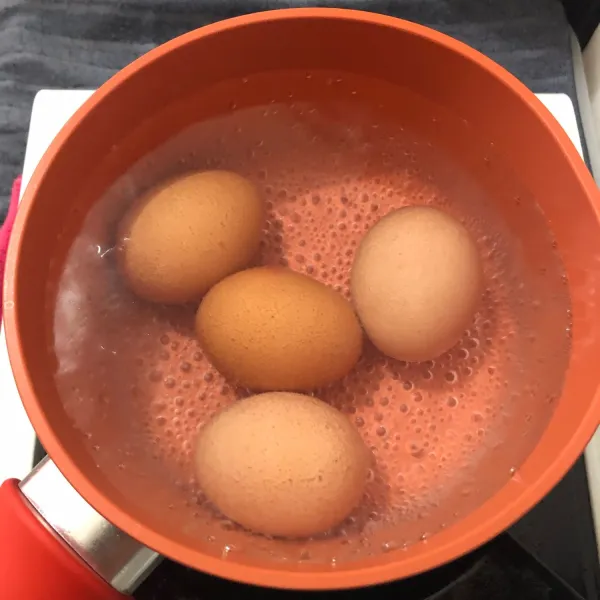 Rebus telur dengan air dingin. Masak hingga matang.