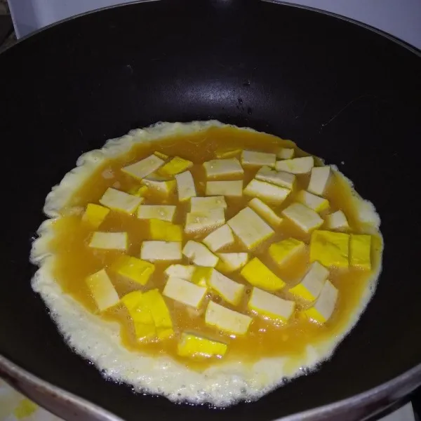 Masukkan potongan tahu, lalu goreng.