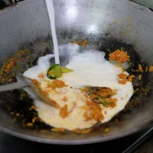 Apabila sudah wangi dan mengeluarkan minyak, masukkan santan sedikit demi sedikit lalu aduk hingga merata.