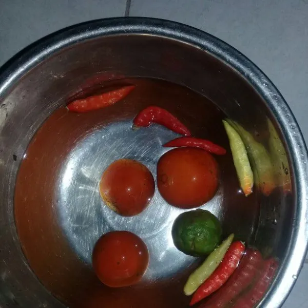 Cuci bersih bahan yang akan digunakan seperti cabe, tomat, dan jeruk sambal.