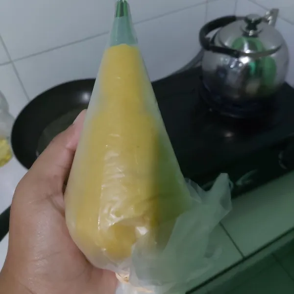 Tuangkan adonan ke dalam piping bag, lalu masukan ke dalam piping bag yang sudah ada spuitnya.