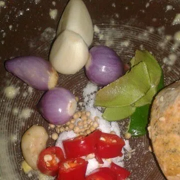 Ulek bumbu jagung gimbal, bawang merah, bawang putih, kencur, cabe merah, ketumbar, garam, dan daun jeruk sampai halus.