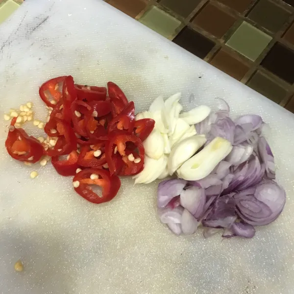 Potong cabai merah besar, bawang putih, dan bawang merah.