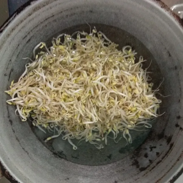 Masak air hingga mendidih, lalu masukan tauge, rebus dengan cara ditutup dan rebus selama 7 menit, lalu bila dengan air dingin.