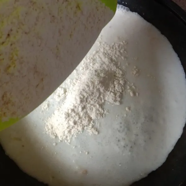 Masukkan tepung terigu. Kecilkan api, aduk rata.