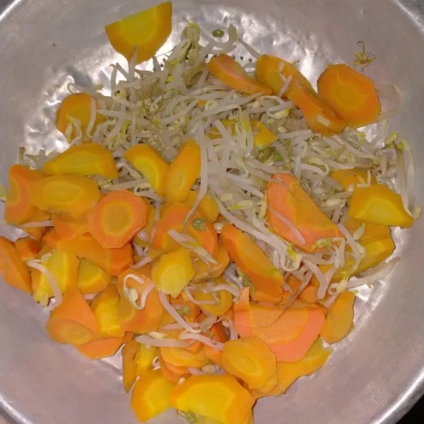 Rebus wortel yang sudah diiris tipis bersama tauge hingga layu. Angkat dan tiriskan.
