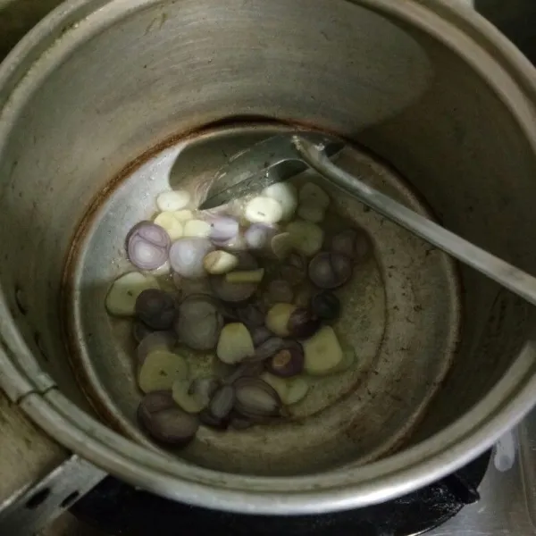 Panaskan minyak goreng dalam panci, tumis bawang merah, dan bawang putih hingga harum dan layu.