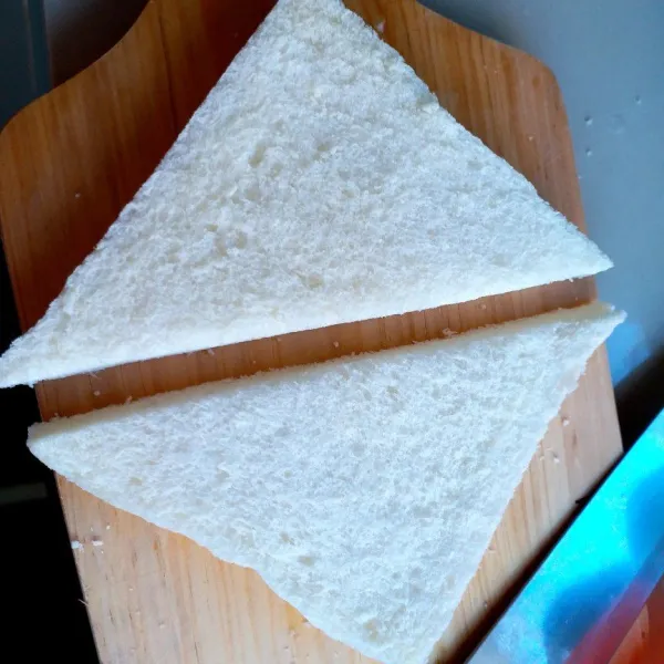 Potong roti tawar bentuk segitiga.