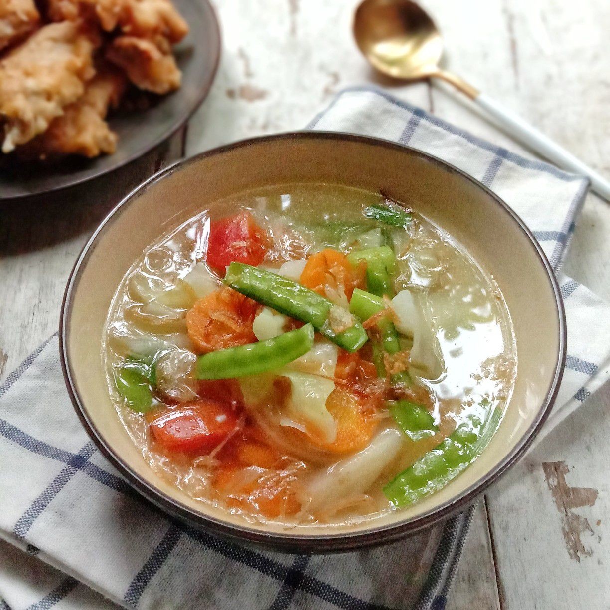 Anak-anak sedang menikmati sayur sop dalam mangkuk