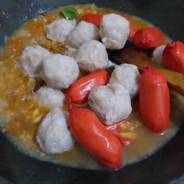 Setelah air mendidih, tambahkan bakso dan sosis. Masak sampai berminyak dan bakso serta sosis matang.
