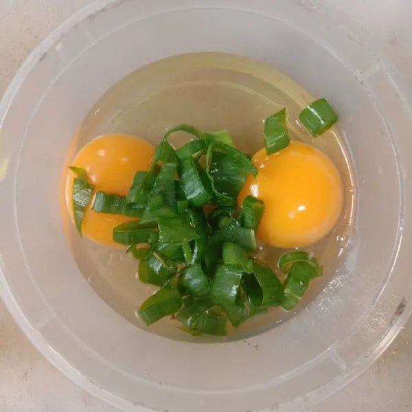 Campur telur, garam, dan daun bawang jadi satu lalu kocok sampai rata.