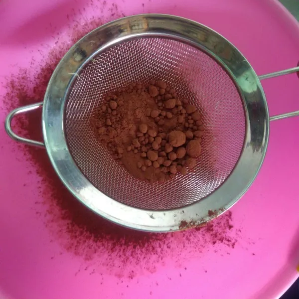 Masukan coklat bubuk yang telah disaring secara bertahap saat hangat.