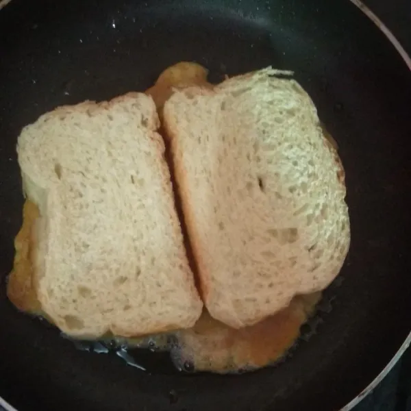 Tangkupkan 2 buah roti diatasnya, lalu balikkan bagian sisa lainnya.