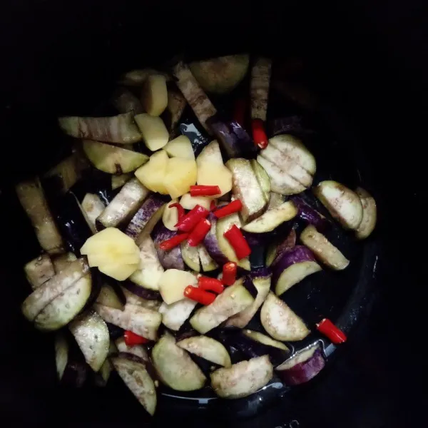 Masukkan kentang, bawang putih, cabai, garam, penyedap rasa dan air kemudian tumis lalu tutup rice cooker