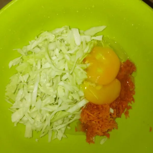 Siapkan 2 butir telur, kol yang sudah diiris tipis, dan wortel parut. Tambahkan laldu bubuk dan lada.
