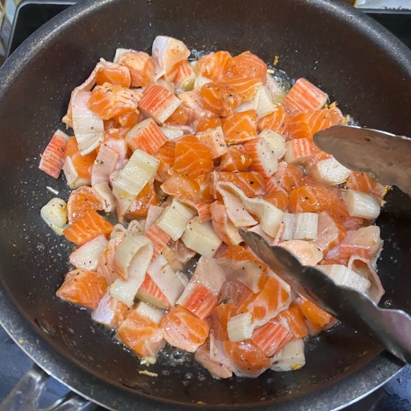 Tumis bawang putih hingga harum. Masukkan ikan salmon dan kani. Bumbui dengan garam dan lada secukupnya. Masak hingga matang.