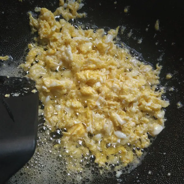 Orak-arik telur, sisihkan ke pinggir wajan.