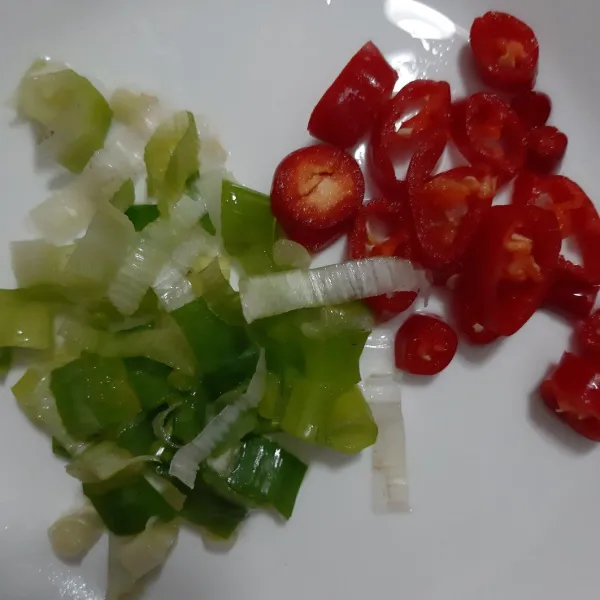 Potong-potong daun bawang dan cabai merah.