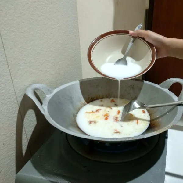 Tuangkan 400 ml santan ke dalam wajan lalu aduk-aduk sebentar.