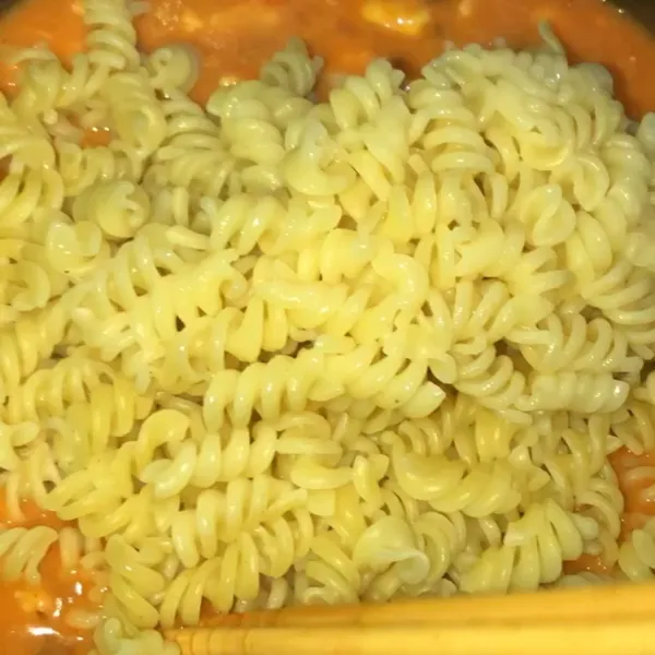 Masukan fusilli yang sudah direbus ke dalam ricecooker. Aduk hingga rata, siapkan wadah tempat (kalau bisa jangan dari bahan plastik saya menggunakan tempat Aluminium Foil yang dijual di supermarket atau toko kue). Angkat dan ratakan ke tempat. Anda boleh langsung menghidangkan ya atau ada 3 pilihan cara lain bagi anak kos untuk lebih menikmati lumeran keju diatasnya.