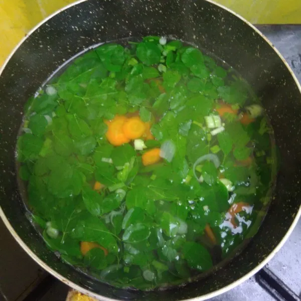 Masukkan daun kelor dan daun bawang, aduk rata. Masak sebentar saja. Bening daun kelor siap disajikan.