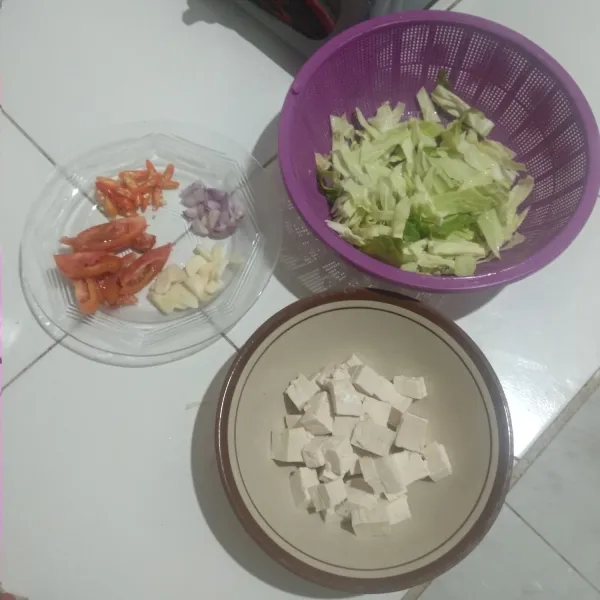 Potong-potong terlebih dahulu tahu, kubis, dan bumbu-bumbu seperti bawang merah, bawang putih, cabai, dan tomat.
