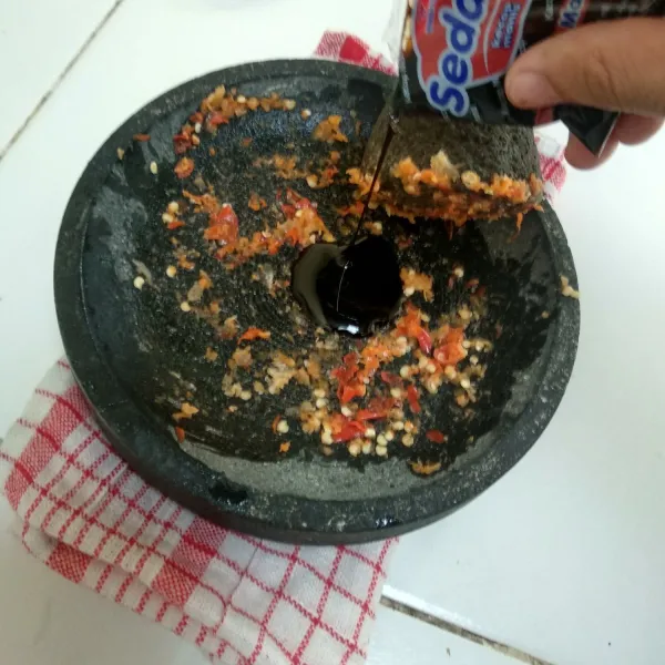 Ulek cabai dan bawang putih, lalu tambahkan 1 saset kecap manis.