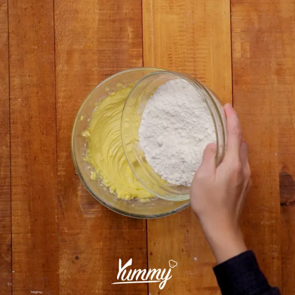 Tambahkan bahan tepung kering sedikit demi sedikit, aduk rata hingga membentuk adonan. Kemudian tambahkan remahan honey cornflakes sebanyak ¾ bagian ke dalamnya, aduk rata.
