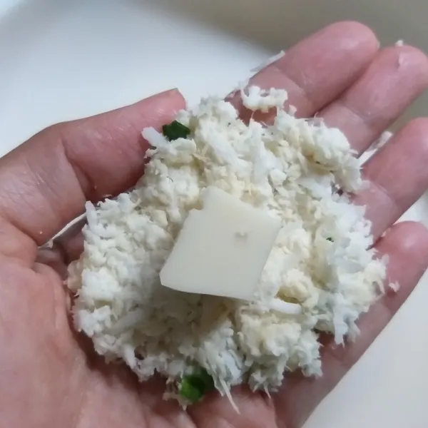 Campurkan singkong, kelapa parut, bawang daun, dan bumbu lainnya lalu aduk hingga merata. Ambil sedikit, pipihkan lalu isi dengan mozarella, kepalkan hingga padat.