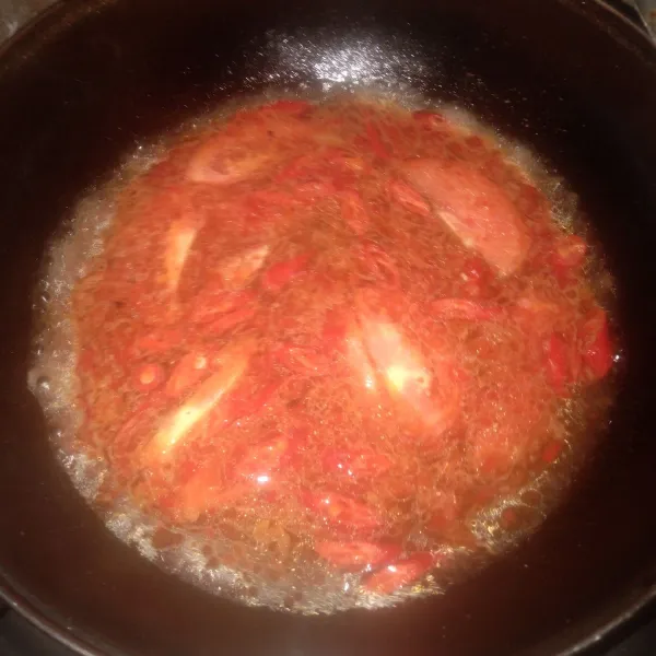 Masukkan air, masak sampai mendidih. Masukkan irisan tomat, cabe merah, garam, gula, dan kaldu bubuk. Aduk rata, koreksi rasa. Masak sampai mengental.