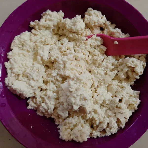 Haluskan tahu dengan menggunakan garpu.